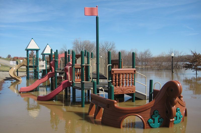 A riverfront playground standing in brown floodwater from the Ohio River